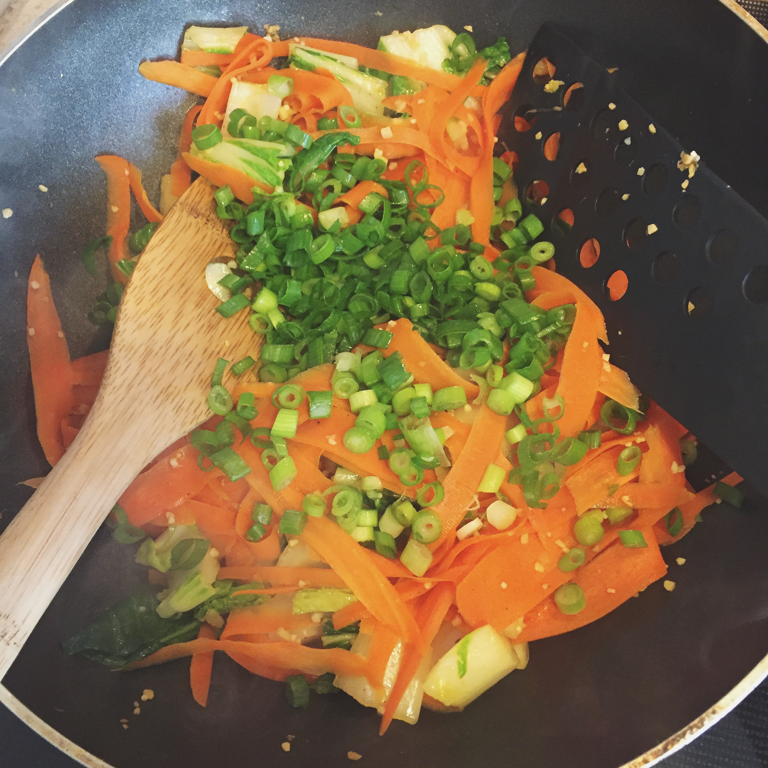Cooked carrot ribbons, bok choy, and green onions. 